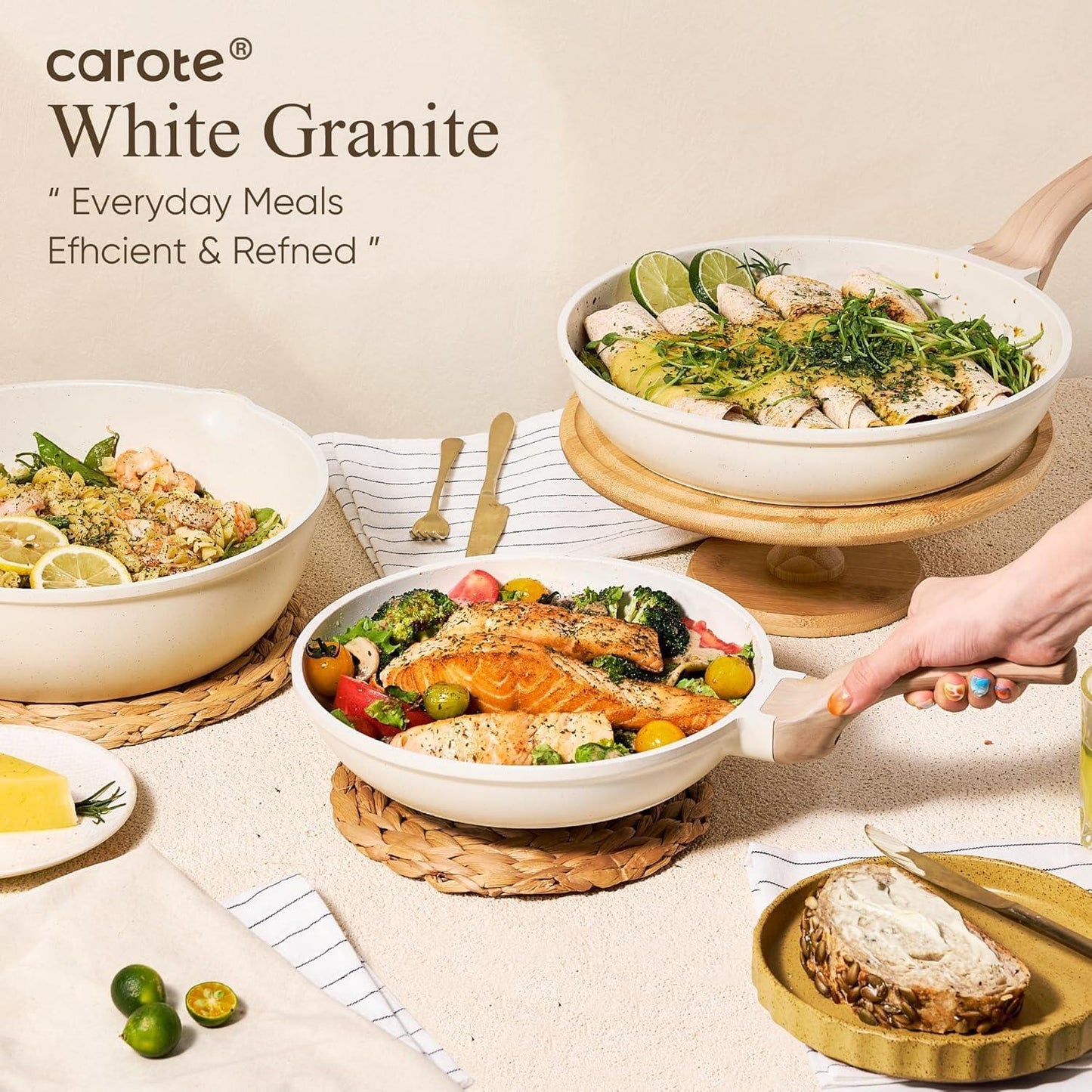 White granite cookware set with cooked salmon, vegetables, and rolled dishes on a dining table