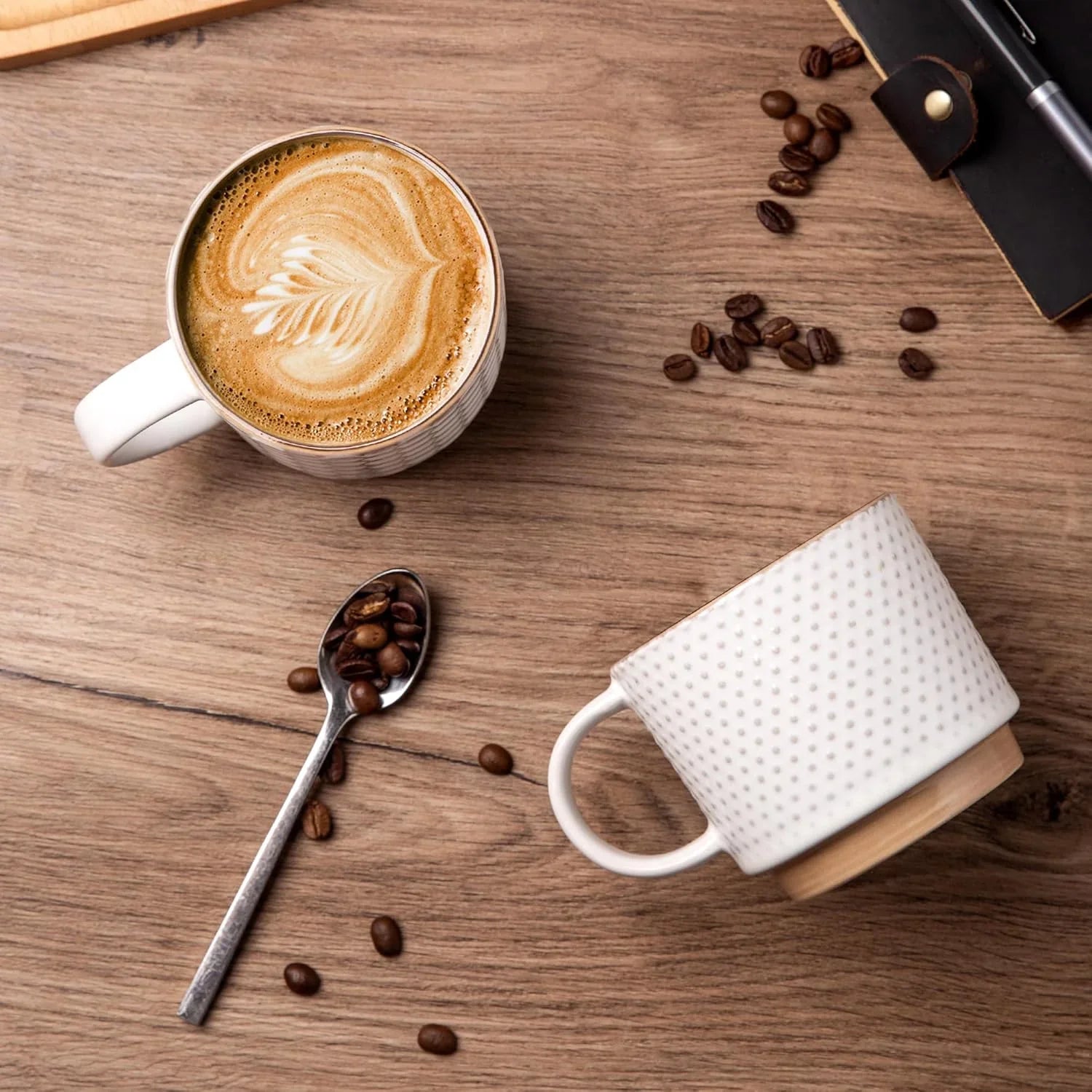 Textured off-white ceramic coffee mug with latte art and coffee beans on wooden surface