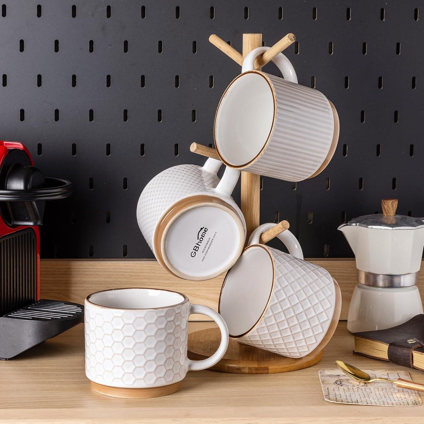 Set of four textured off-white ceramic coffee mugs with wooden coaster and stand on wooden counter