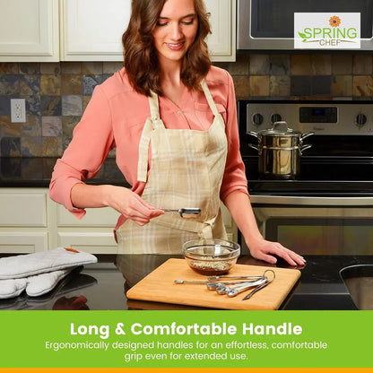 Woman in kitchen using stainless steel measuring spoon over glass bowl on wooden cutting board