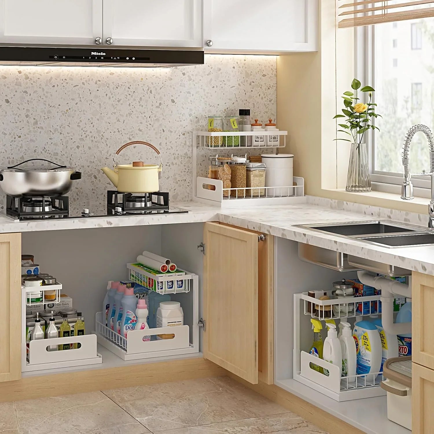 Modern kitchen with under-sink organizer and pull-out storage shelves holding cleaning supplies and pantry items
