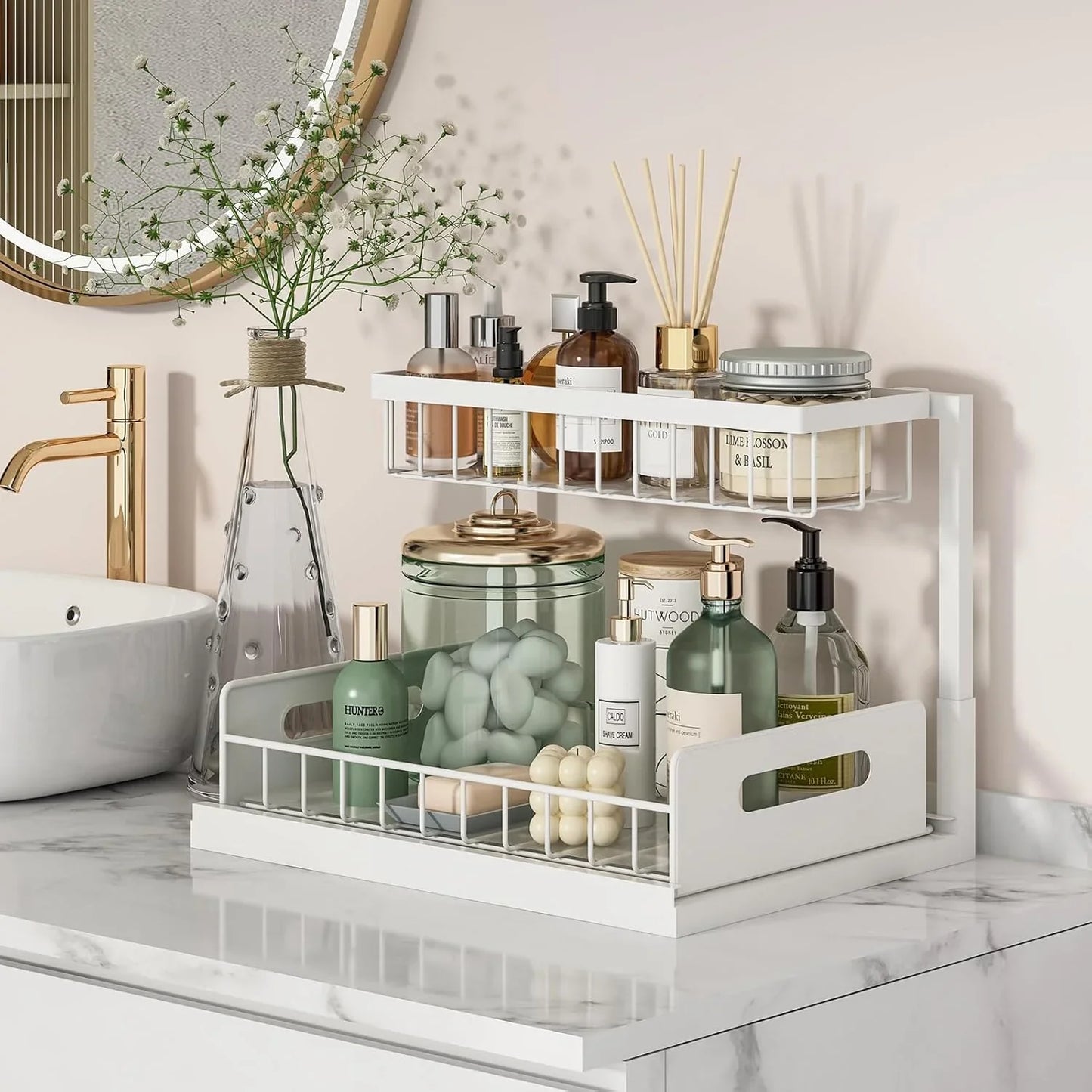 White 2-tier bathroom organizer with skincare bottles, jars, and decorative vase on marble countertop