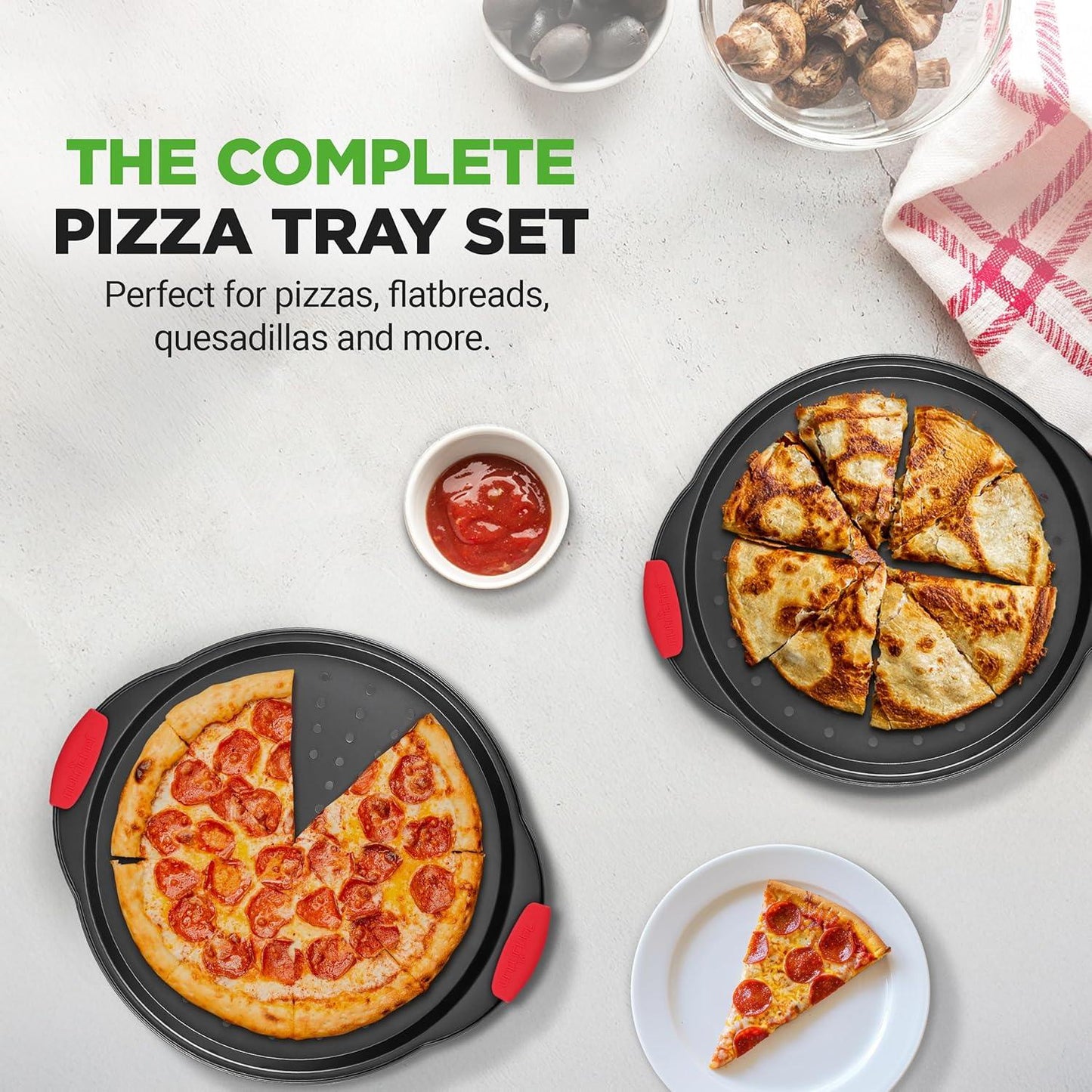 Two 13-inch nonstick perforated pizza pans with red silicone handles holding sliced pepperoni pizza and quesadilla, with dipping sauce and mushrooms
