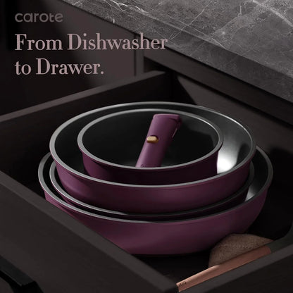 Set of stacked purple nonstick frying pans with a detachable handle in a dark kitchen drawer