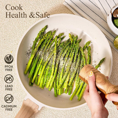 White granite frying pan with cooked asparagus being seasoned with pepper, healthy nonstick cookware