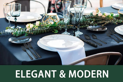 Elegant table setting with 24-piece black stainless steel flatware and steak knives on navy tablecloth