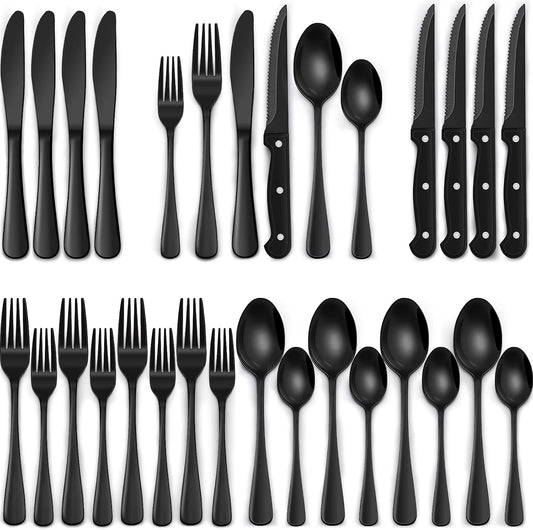 24-piece black stainless steel silverware set with steak knives arranged on a table.