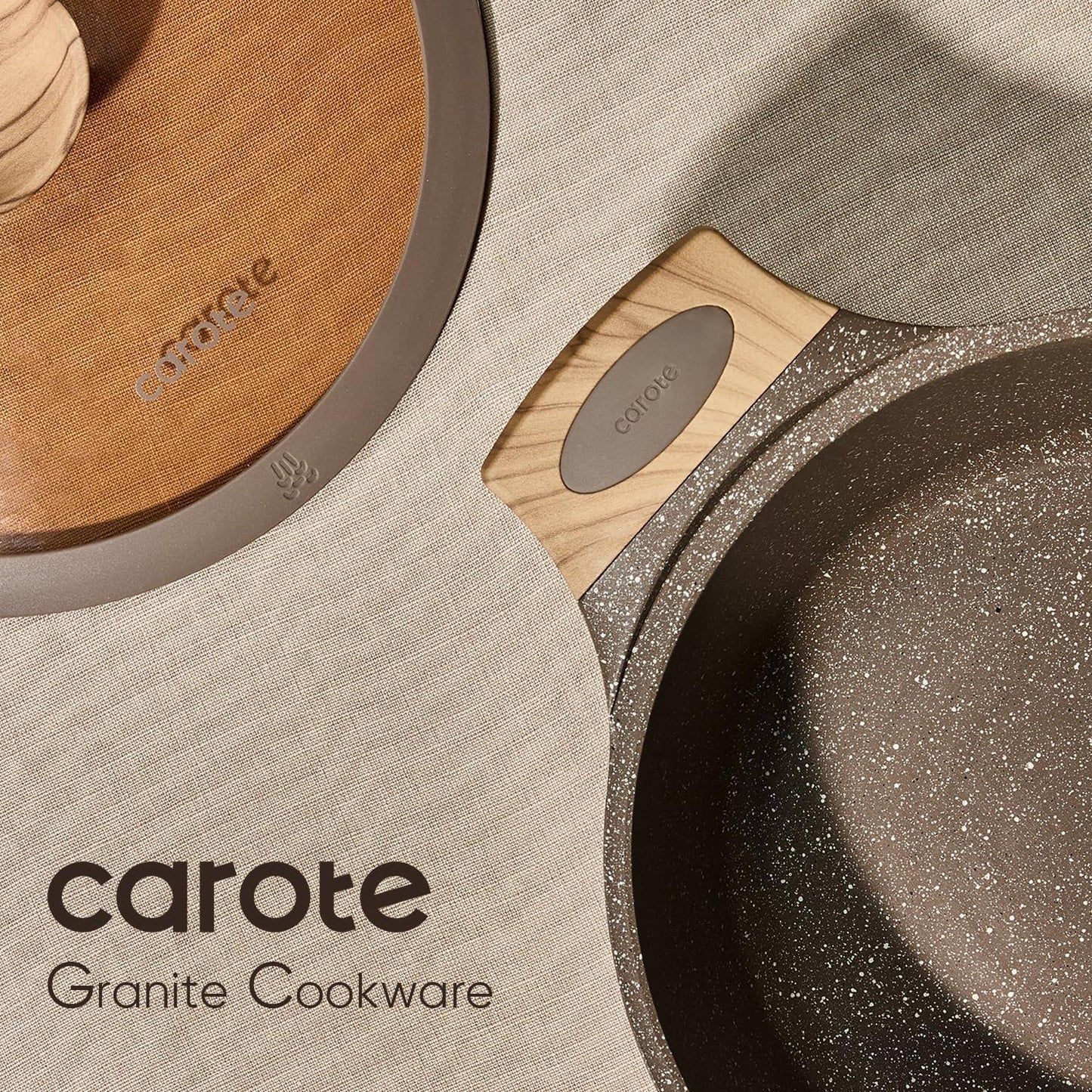 Close-up of Carote granite nonstick cookware with wood-style handles and lids on fabric background