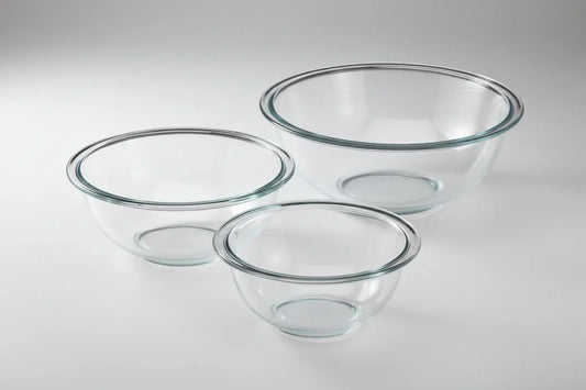 Set of three clear glass mixing bowls in small, medium, and large sizes on a white background