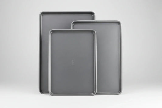 Set of three nested gray nonstick carbon steel baking sheets in small, medium, and large sizes