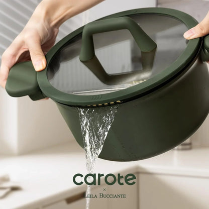 Green pot with glass lid draining water through built-in strainer in modern kitchen