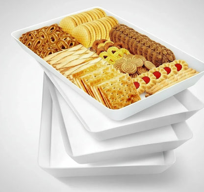 Stack of four white serving trays with top tray holding assorted cookies and crackers