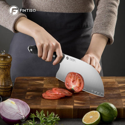 Person slicing tomato on wooden cutting board with Fintiso kitchen knife and fresh ingredients