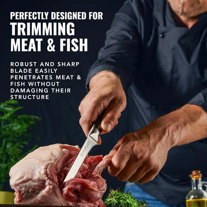Chef using a sharp boning knife to trim raw meat with herbs and olive oil nearby