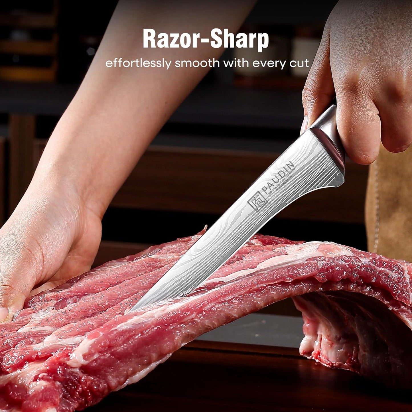 Hand holding a razor-sharp PAUDIN boning knife cutting raw pork ribs on wooden surface