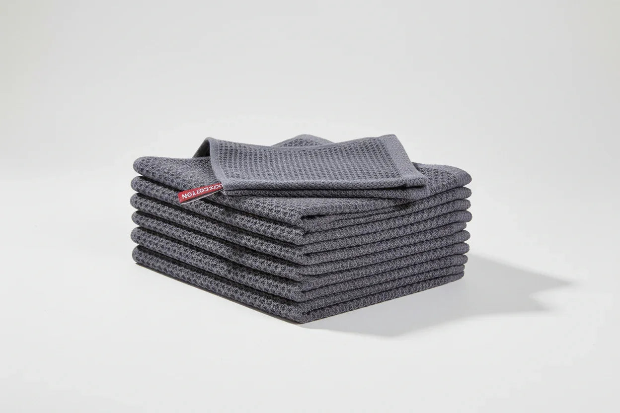 Stack of six dark grey 100% cotton waffle weave kitchen dish cloths folded neatly