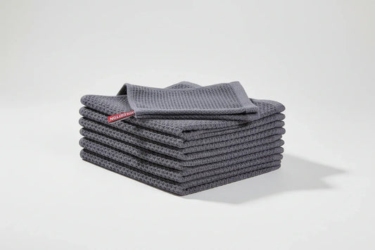 Stack of six dark grey 100% cotton waffle weave kitchen dish cloths folded neatly