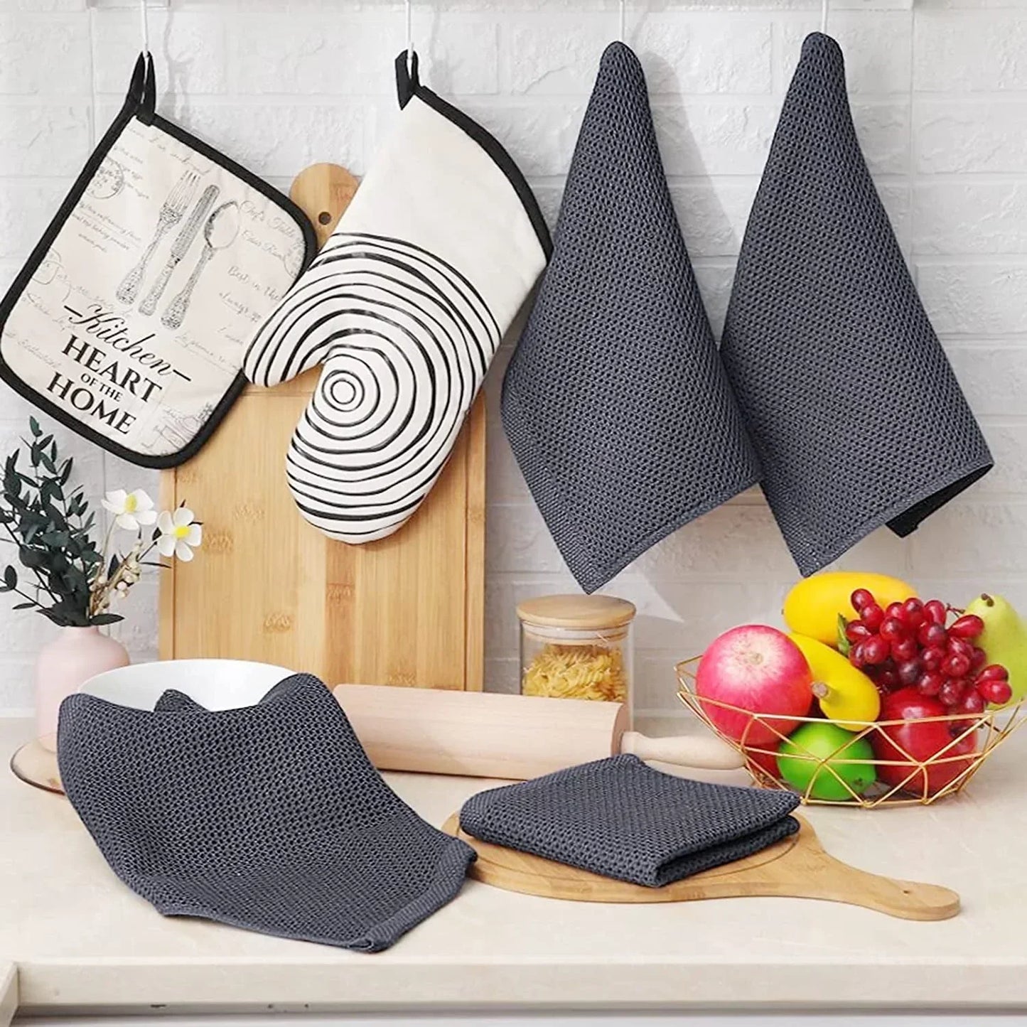 Dark grey cotton waffle weave kitchen dish cloths with oven mitts and cutting boards in a modern kitchen