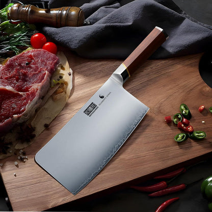 7-inch Japanese high carbon steel meat cleaver with wooden handle on wooden cutting board with raw steak and chopped chili peppers