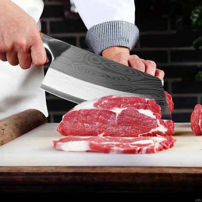 Chef slicing raw red meat on white cutting board with Damascus pattern stainless steel cleaver