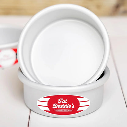 Fat Daddio's anodized aluminum round cake pans set with red label on white wooden surface