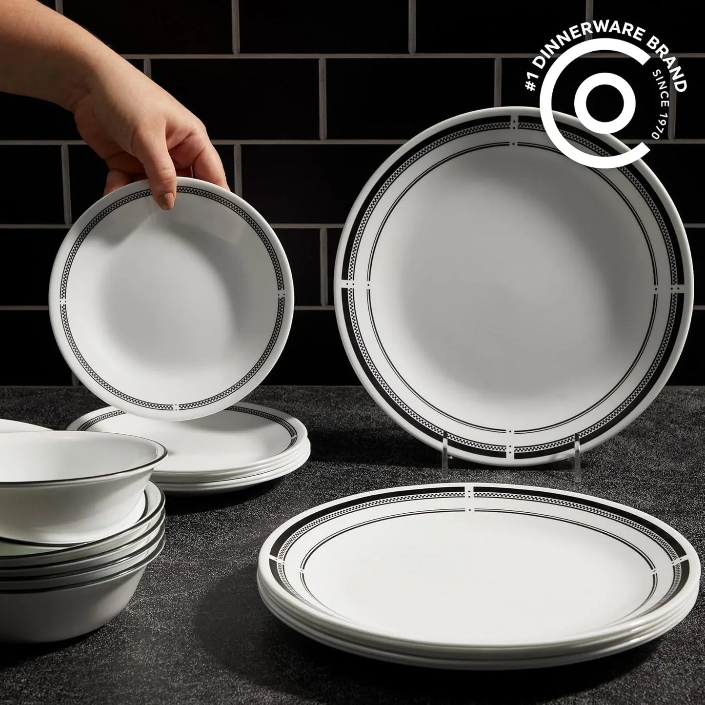Brasserie 18-piece round white Vitrelle dinnerware set with black trim on dark textured surface
