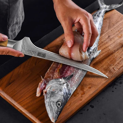 Hand filleting fresh fish with Japanese Damascus boning knife on wooden cutting board