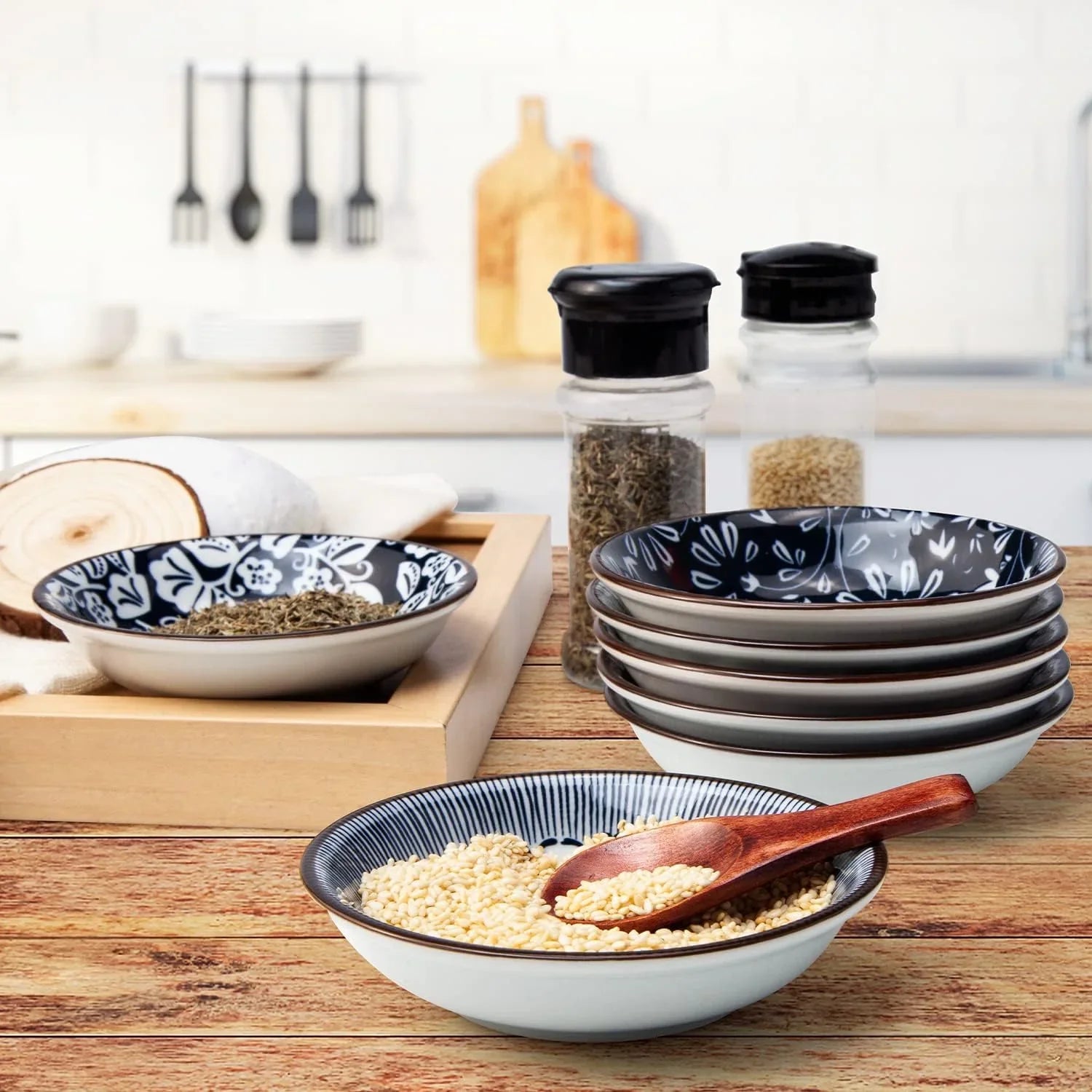 Vintage blue ceramic dipping bowls with sesame seeds and herbs on wooden kitchen countertop