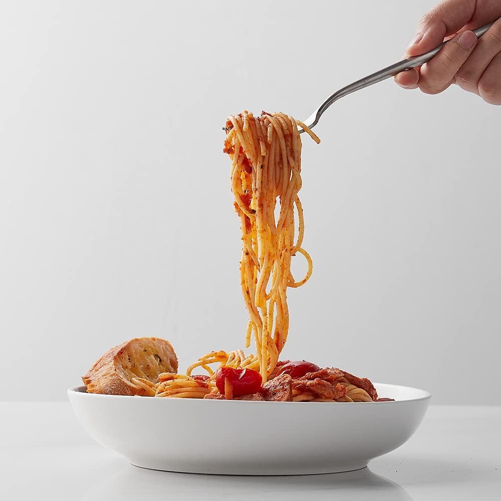 White pasta bowls placed in a dishwasher rack for easy cleaning.