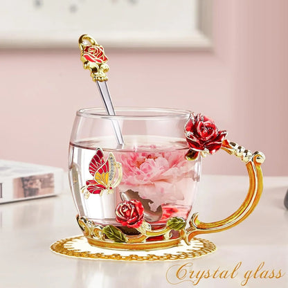 Crystal glass tea cup with red rose and butterfly decorations, filled with pink flower tea