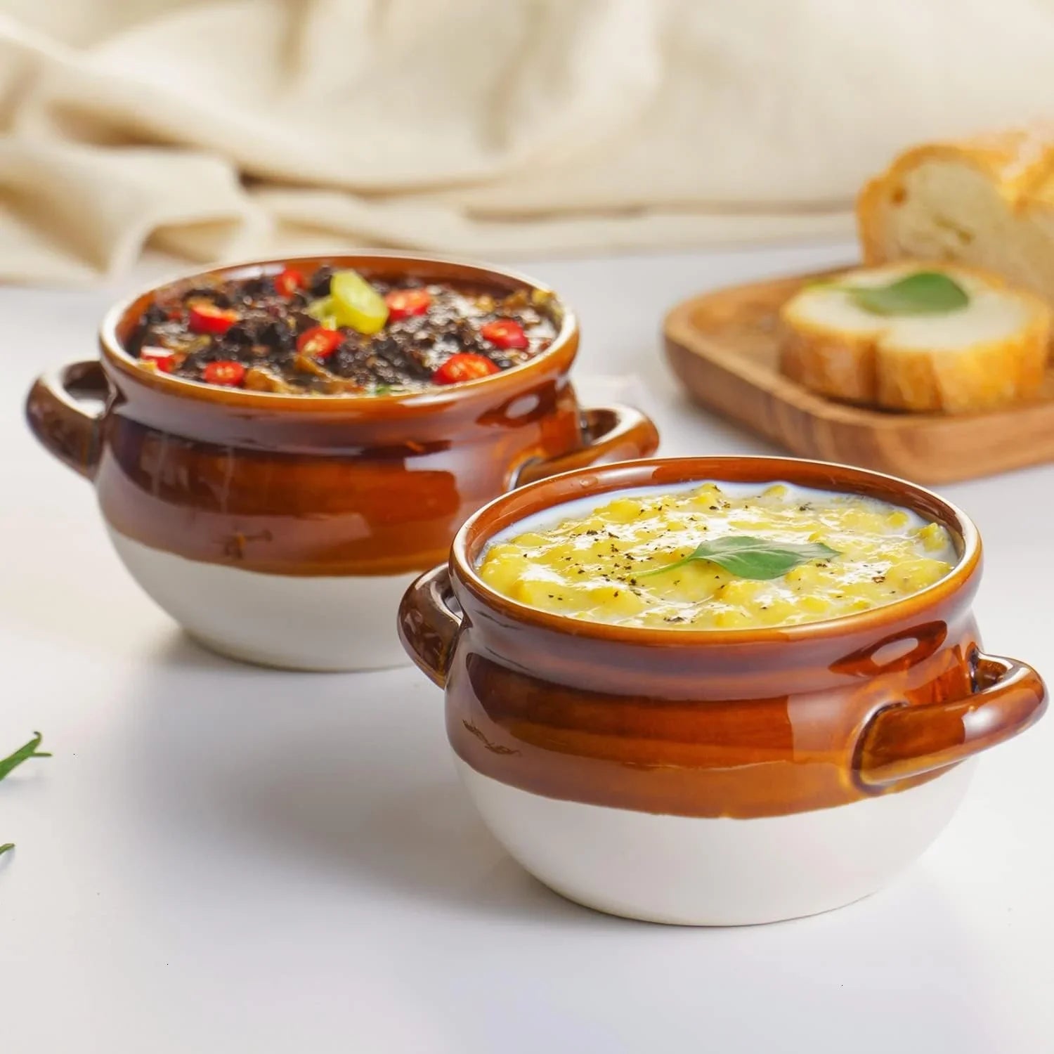 Set of two 16 oz ceramic soup crocks with handles, one filled with creamy soup and the other with chunky soup topped with red peppers