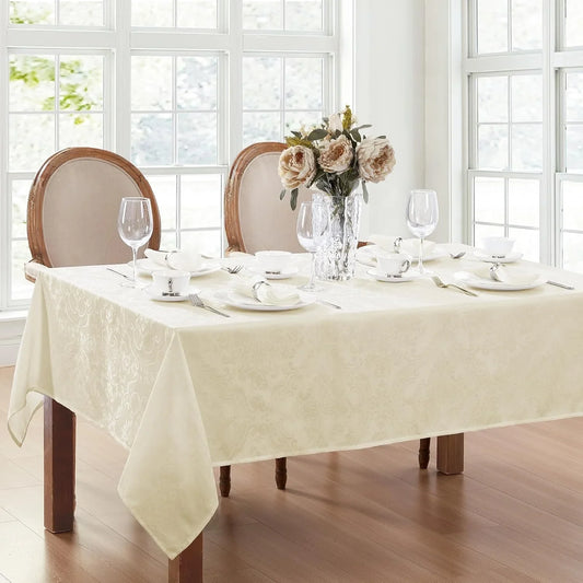 Dining table set with a checkered tablecloth, wine bottle, glasses, and plates.