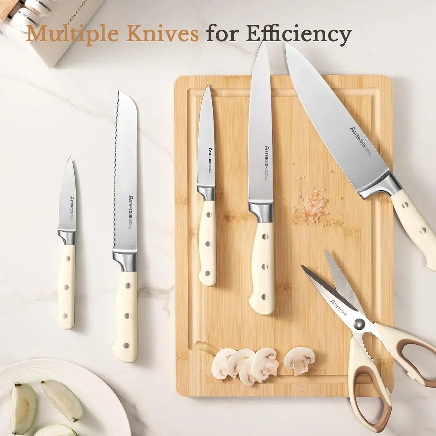 14-piece cream-handled kitchen knife set with full tang stainless steel blades and kitchen scissors on a wooden cutting board with sliced mushrooms