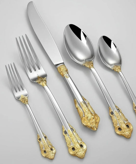 Luxurious stainless steel flatware set with intricate gold accent handles including forks, knife, and spoons