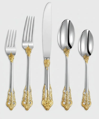 Silver flatware set with intricate gold accents, including forks, knife, and spoons on white background
