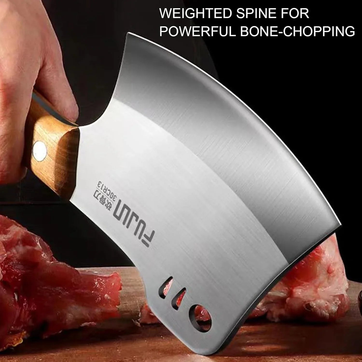 Hand holding heavy-duty meat cleaver with wooden handle chopping raw meat and bone
