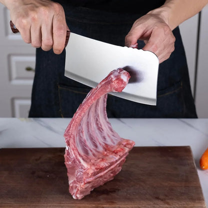 Person holding a 7-inch heavy-duty meat cleaver over a rack of raw ribs on a wooden cutting board