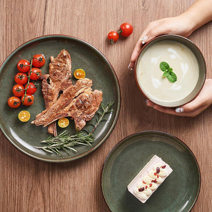 Green reactive glaze stoneware plates with grilled meat, cherry tomatoes, rosemary, dessert, and cream soup