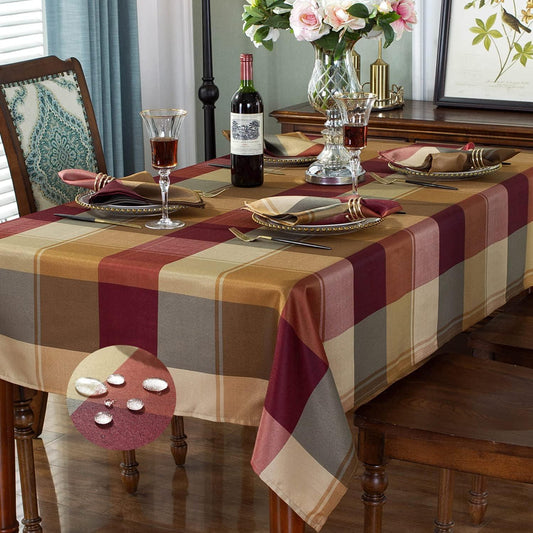 Dining table set with a checkered tablecloth, wine bottle, glasses, and plates.