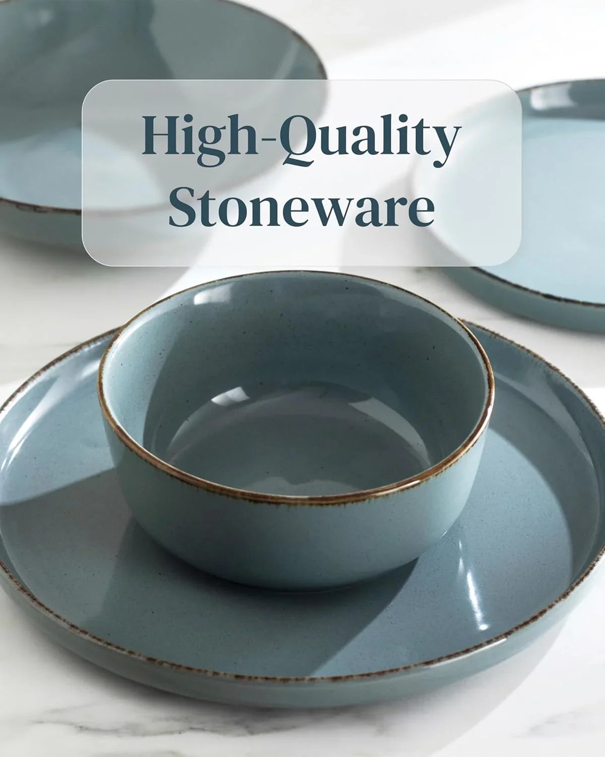 Rustic smoky blue stoneware bowl and dinner plate with brown rim on marble surface