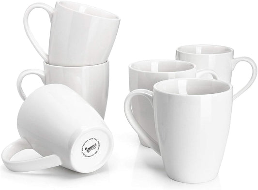 Set of six 16oz white porcelain coffee mugs arranged on a kitchen counter.