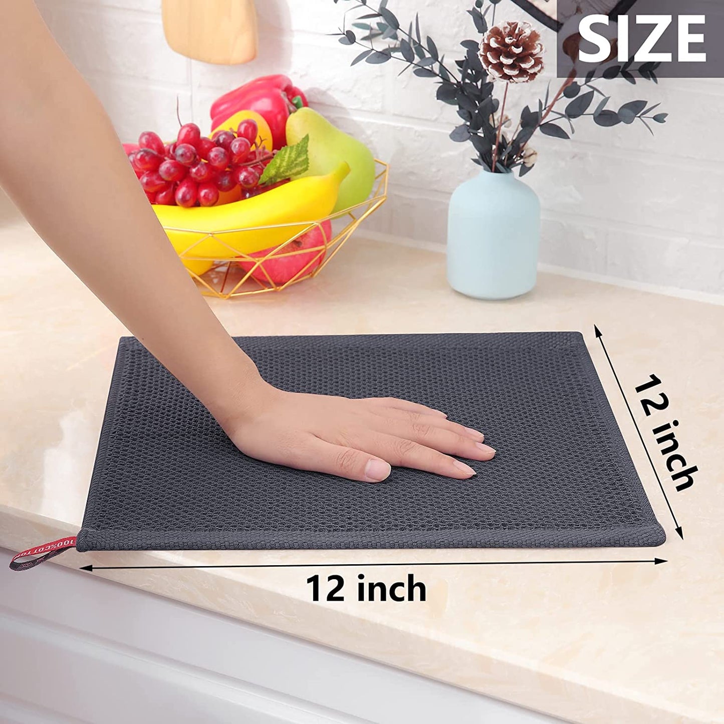 Hand using a soft cotton dish cloth to wipe a kitchen countertop.