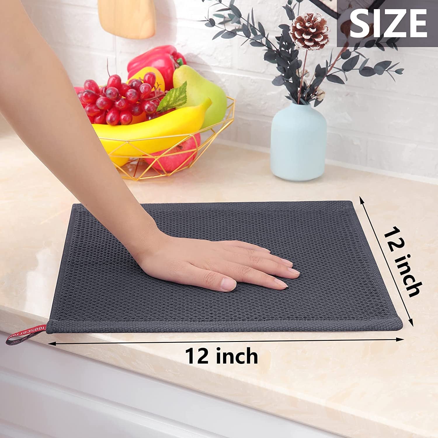 Hand using a soft cotton dish cloth to wipe a kitchen countertop.