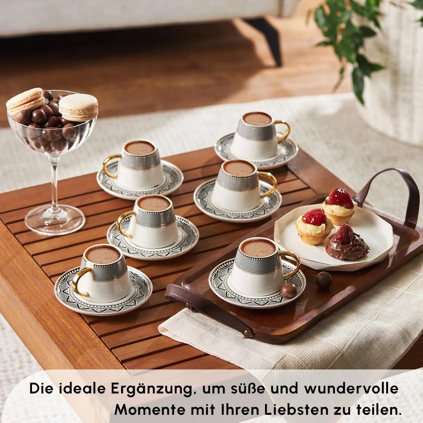 Set of six porcelain Turkish coffee cups with gold handles and patterned saucers on wooden table with desserts and chocolates