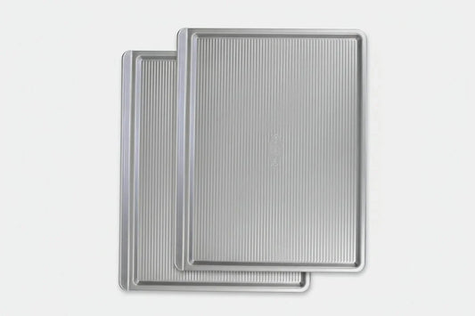 Two warp-resistant nonstick metal baking cookie sheets with ribbed surfaces stacked
