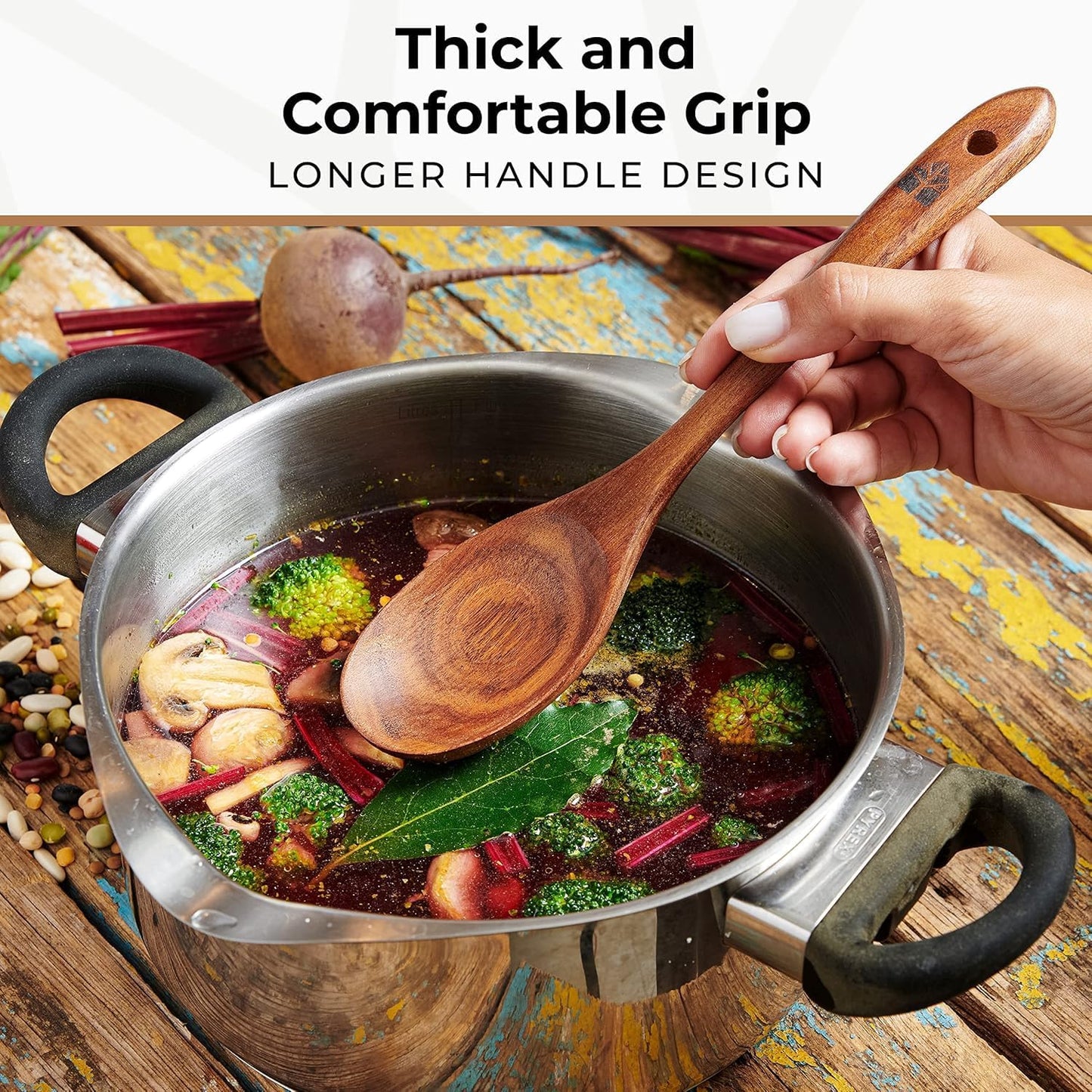Teak wooden soup ladle and skimmer spoon resting on the edge of a cooking pot.